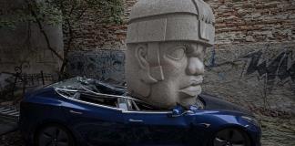 Un Tesla aplastado por colosal escultura indígena, el provocador arte urbano en México