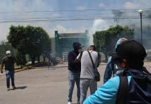 Activistas de Ayotzinapa lanzan petardos y causan incendios frente al Ejército mexicano