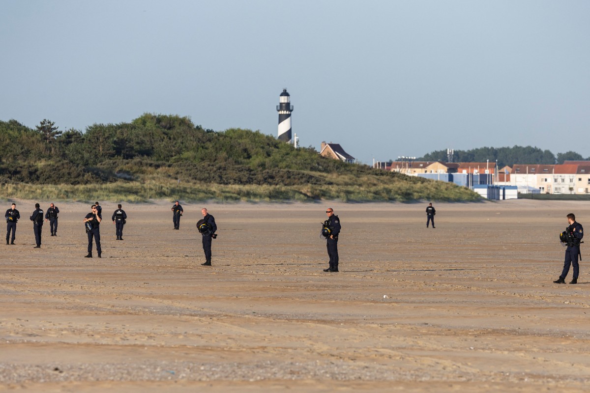 Inmigrantes con niños corren hacia abarrotadas barcas en el norte de Francia Inmigrantes con niños corren hacia abarrotadas barcas en el norte de Francia