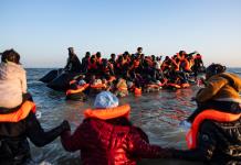 Inmigrantes con niños corren hacia abarrotadas barcas en el norte de Francia