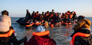 Inmigrantes con niños corren hacia abarrotadas barcas en el norte de Francia