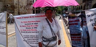 Trabajador de Secretaría de Salud se encadena; pide que se acate laudo para tener salario justo