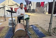 Una batería con cubos de plástico: la terapia de un músico gazatí en medio de la miseria