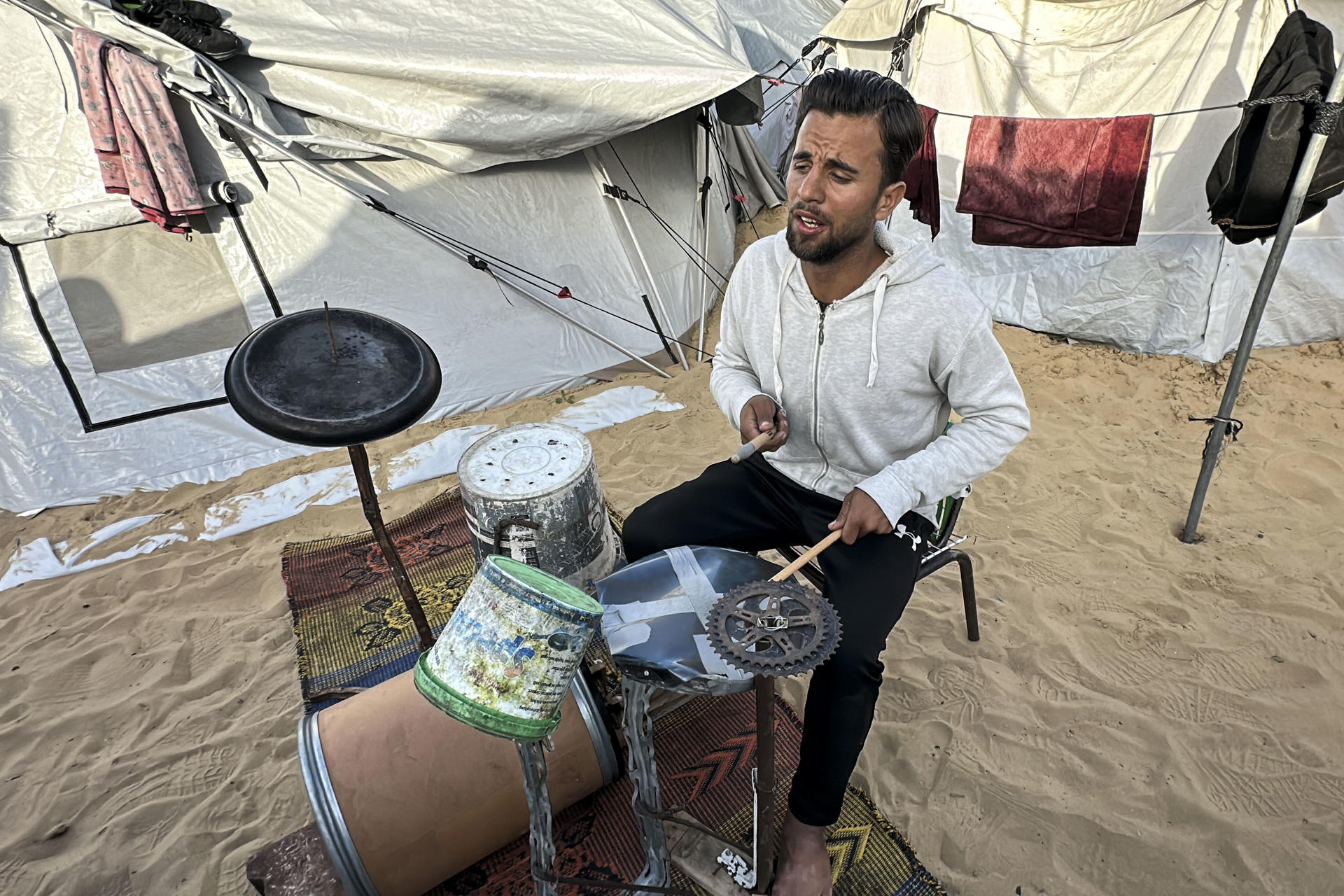 Una batería con cubos de plástico: la terapia de un músico gazatí en medio de la miseria